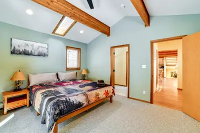 a bedroom with a bed in a room with a wooden ceiling at Golf, Fish and Ski Retreat with Game Room in Thompson in Thompson