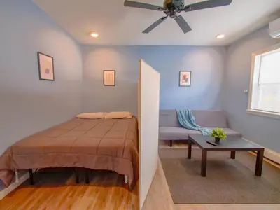 a bedroom with a bed and a couch and a ceiling fan at New Studio unit near the heart of NYC in Jersey City