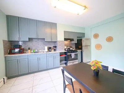 a kitchen with blue cabinets and a table in it at New Studio unit near the heart of NYC in Jersey City