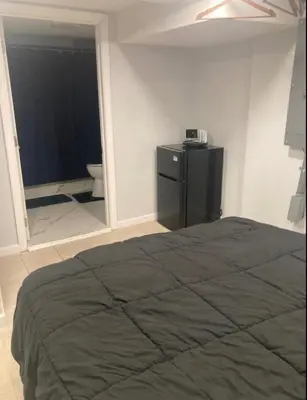 a bedroom with a bed and a bathroom with a toilet at Cozy bedroom with en-suite bathroom in Naugatuck