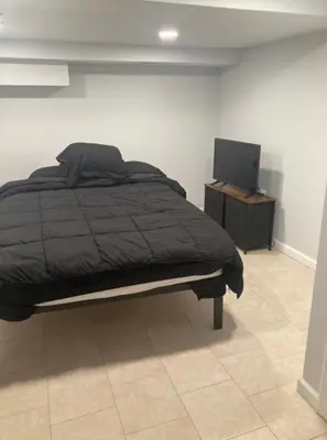 a bedroom with a bed and a tv on a table at Cozy bedroom with en-suite bathroom in Naugatuck