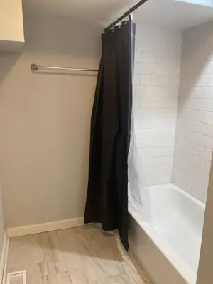 a bathroom with a shower with a black shower curtain at Cozy bedroom with en-suite bathroom in Naugatuck