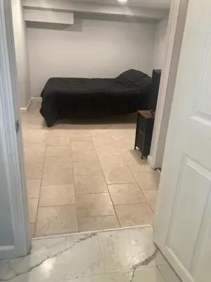 a bedroom with a bed and a tiled floor at Cozy bedroom with en-suite bathroom in Naugatuck