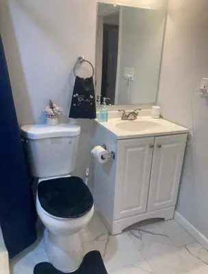 a bathroom with a sink and a toilet and a mirror at Cozy bedroom with en-suite bathroom in Naugatuck