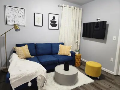 a living room with a blue couch and a table at Comfy Fairmount in Newark