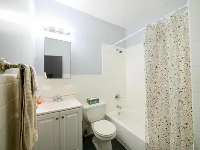 a white bathroom with a toilet and a sink at Sleek one-bedroom abode near NYC in Jersey City