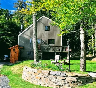 a house with a bench and a stone wall at 6BD 3BA - Mount Snow VT - Ski-Back Trail - Shuttle in Dover