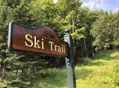 a sign for a ski trail in a field at 6BD 3BA - Mount Snow VT - Ski-Back Trail - Shuttle in Dover