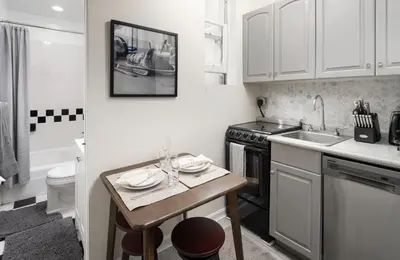 a small kitchen with a table and a sink at Cozy Apartment in the Upper East Side in New York