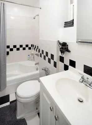 a white bathroom with a toilet and a sink at Cozy Apartment in the Upper East Side in New York