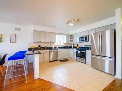 a kitchen with white cabinets and a stainless steel refrigerator at Impressive 3bed 2bath apt close to NYC in Jersey City