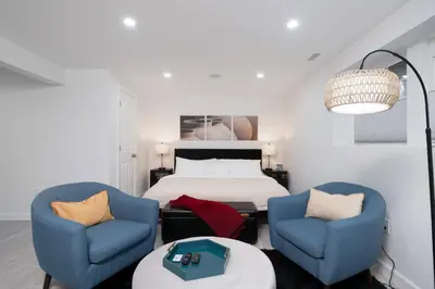 a bedroom with two blue chairs and a bed at Upscale 4BR Retreat at the Reservoir! in Bridgeport