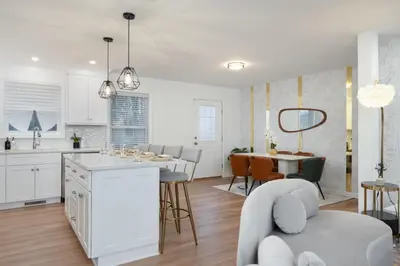 a white kitchen and living room with a table and chairs at Upscale 4BR Retreat at the Reservoir! in Bridgeport
