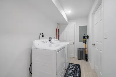 a bathroom with two sinks and a washer and dryer at Upscale 4BR Retreat at the Reservoir! in Bridgeport