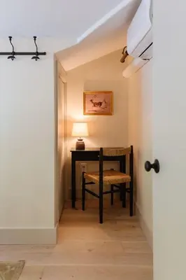 a hallway with a chair and a desk with a lamp at The Bend Micro Resort in Phoenicia