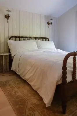 a bedroom with a large bed with white sheets at The Bend Micro Resort in Phoenicia