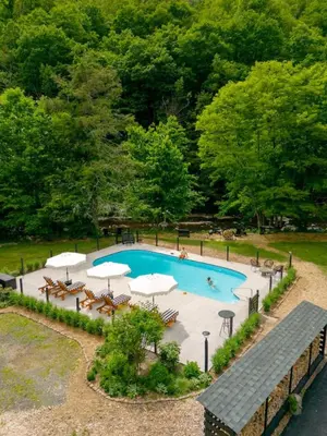 an overhead view of a swimming pool with tables and umbrellas at The Bend Micro Resort in Phoenicia