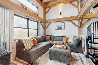a living room with a couch and a table at Timber Riverhouse in Readsboro