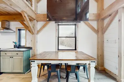 a wooden table in a kitchen with a window at Timber Riverhouse in Readsboro