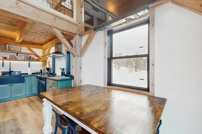 a kitchen with a wooden table and a window at Timber Riverhouse in Readsboro