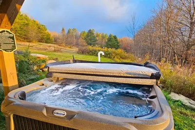 a hot tub in the middle of a field at Timber Riverhouse in Readsboro