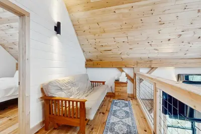 a small room with a couch and a bed at Timber Riverhouse in Readsboro