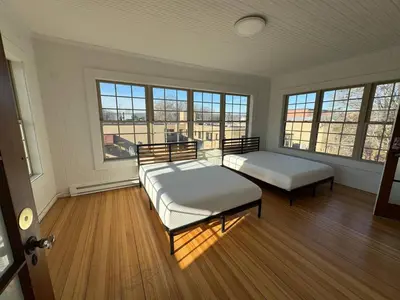 a bedroom with two beds in a room with windows at Warm and Cozy 4Bd 2Bath in Southington