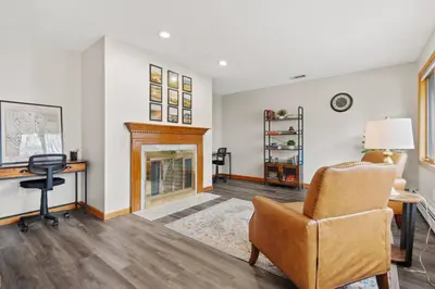 a living room with a fireplace and a chair at 40 Spacious Sleek Cozy in Middletown
