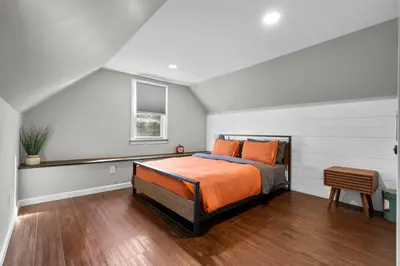 a bedroom with a bed with orange pillows on it at 22- 4 Br 2 Ba House - Central CT in New Britain