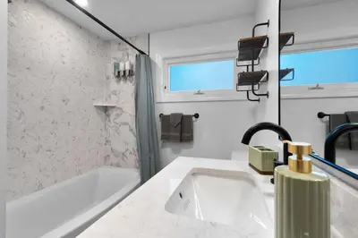 a white bathroom with a sink and a bath tub at 27- Luxury Collection in Southington