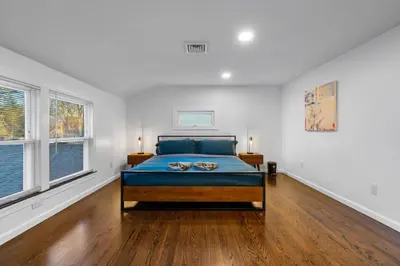 a bedroom with a bed and two windows at 27- Luxury Collection in Southington