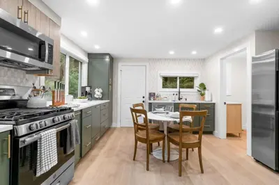 a kitchen with green cabinets and a table and chairs at 37 - Luxury Collection in Stratford