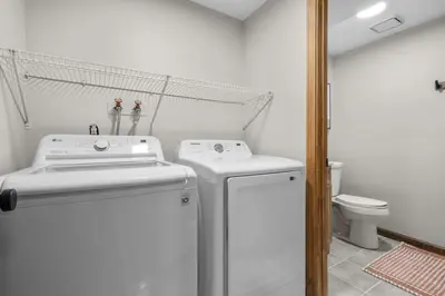 a bathroom with a washer and dryer and a toilet at 29 - Modern 5 Bedroom 2 Bath in Middletown