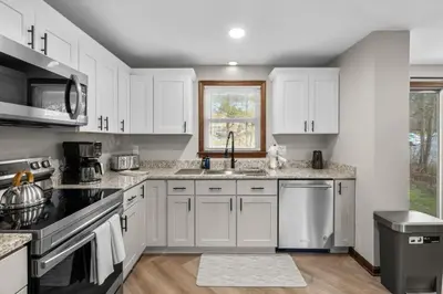 a kitchen with white cabinets and a sink at 29 - Modern 5 Bedroom 2 Bath in Middletown