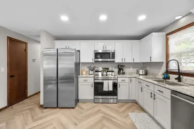 a kitchen with white cabinets and a stainless steel refrigerator at 29 - Modern 5 Bedroom 2 Bath in Middletown