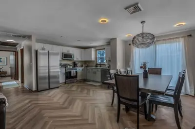 a kitchen and dining room with a table and refrigerator at 29 - Modern 5 Bedroom 2 Bath in Middletown