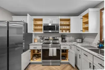 a kitchen with white cabinets and a stainless steel refrigerator at 29 - Modern 5 Bedroom 2 Bath in Middletown