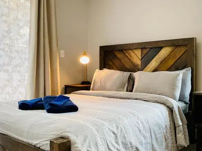 a bedroom with a large bed with a wooden headboard at 16 A COZY GETAWAY 4BED 3BATH HOME W FIRE PIT in Southington