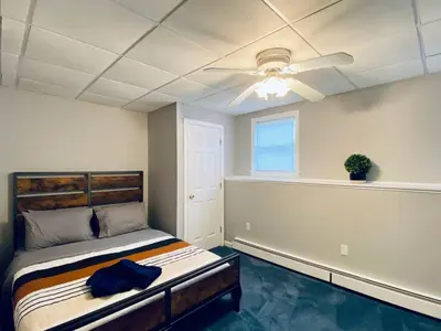 a bedroom with a bed and a ceiling fan at 16 A COZY GETAWAY 4BED 3BATH HOME W FIRE PIT in Southington