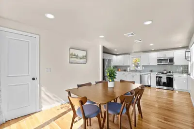 a kitchen and dining room with a wooden table and chairs at 26 Beautifully Renovated 2 BR Home in Plainville