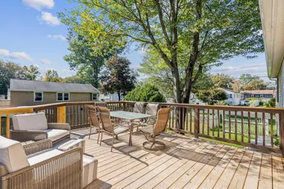 a patio with a table and chairs on a deck at 26 Beautifully Renovated 2 BR Home in Plainville