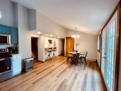 a kitchen and dining room with a table and chairs at 24 Serenity A Lakefront Cottage Retreat in Middletown