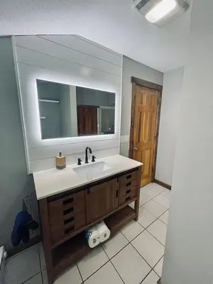 a bathroom with a sink and a mirror at 24 Serenity A Lakefront Cottage Retreat in Middletown