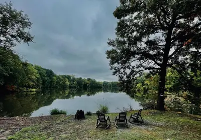 a group of chairs sitting next to a river at 24 Serenity A Lakefront Cottage Retreat in Middletown