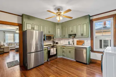 a kitchen with green cabinets and a stainless steel refrigerator at 25 Massive 5 BR in Downtown Southington in Southington