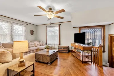 a living room with a couch and a ceiling fan at 25 Massive 5 BR in Downtown Southington in Southington