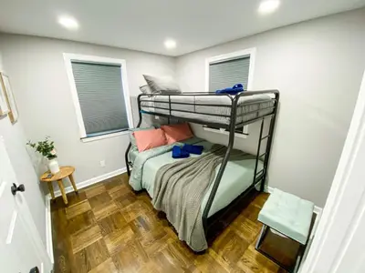 a bedroom with two bunk beds and a wooden floor at 21 COMFORTABLE AND LUXURIOUS in Plainville