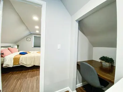 a bedroom with a bed and a table with a chair at 21 COMFORTABLE AND LUXURIOUS in Plainville