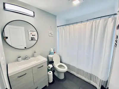 a bathroom with a sink and a toilet and a mirror at 23 COMFORT AND LUXURY 3 BR 2 BA House in Southington