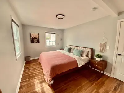 a bedroom with a bed and a wooden floor at 23 COMFORT AND LUXURY 3 BR 2 BA House in Southington
